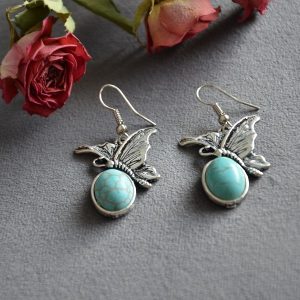 Oorbellen met turquoise kleur steenovaal met mooie vlindertjes erop