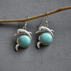 Turquoise oorbellen in de vorm van een dolfijntje